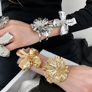Oversized gold and silver metal flower bracelets and rings with hammered texture finish