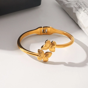 Detailaufnahme der goldenen Schmetterlingsanhänger an einem eleganten Armreif