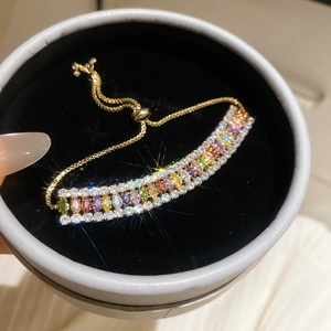 Détail d'un bracelet étincelant plaqué or 18 carats avec des oxydes de zirconium colorés.