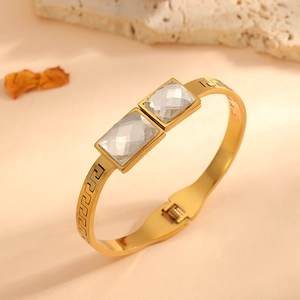 Detailed view of a gold-plated stainless steel bangle with Greek key engraving