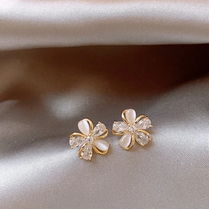 Close-up detail of 18k gold plated flower stud earrings with zircon and cat-eye stones