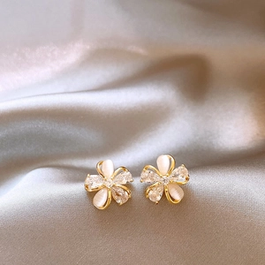 Detailed view of elegant flower stud earrings with cat-eye stones and cubic zirconia