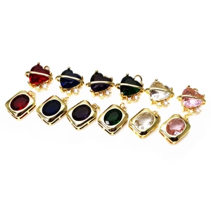 Close-up of colorful heart and oval crystal pendants with gold-plated star and planet motifs