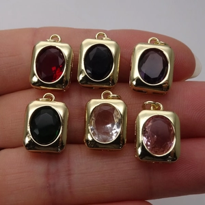 Hand holding six colorful heart and oval crystal charms with gold-plated metal base set