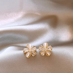 Close-up of elegant flower stud earrings with 18k gold plating and shimmering zircons