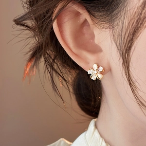 Close-up of 18k gold plated flower stud earring with sparkling zircon details