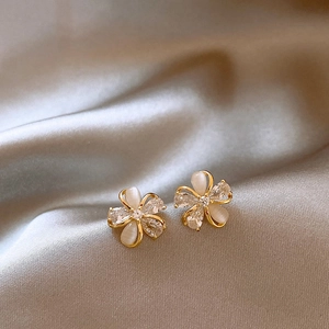 Detailed macro view of elegant 18k gold plated flower stud earrings set with sparkling zircons