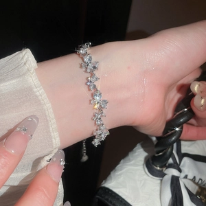 Primer plano detallado de una pulsera de flores de circón brillante en una muñeca elegante