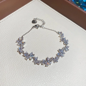 Detalle de una pulsera con dijes de mariposas de circón brillante y cierre de langosta