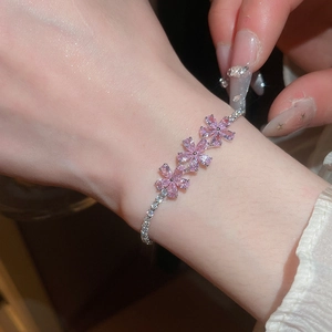 Detalle de una pulsera de flores de circonita rosa con elegante acabado plateado en muñeca