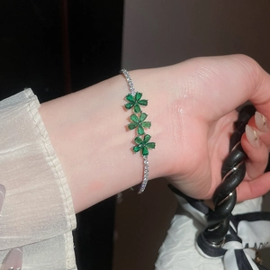 Detalle de una pulsera de flores de circón vintage con piedras verdes brillantes