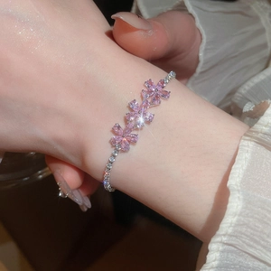 Primer plano de una elegante pulsera de flores de cristal rosa en la muñeca de una mujer