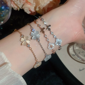 Detailaufnahme von Katzenaugenstein-Armbändern mit Blumen- und Schmetterlingsanhängern