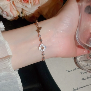 Exquisites Detail eines eleganten Blumen- und Schmetterlingsarmbands mit Zirkonsteinen
