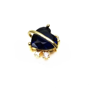 Detail of dark blue heart crystal charm with golden Saturn ring and star element