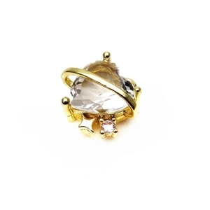 Macro detail of heart-shaped crystal pendant with golden planet ring and star accents
