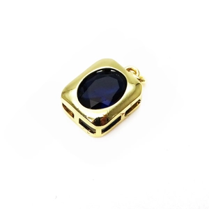 Macro shot of oval blue stone pendant in vintage gold frame with openwork details