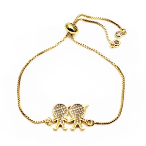 Detailed macro of golden adjustable bolo bracelet with zircon paved boy and girl charms
