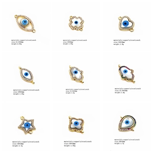 Macro view of gold-plated evil eye charms with cubic zirconia and shell inlays