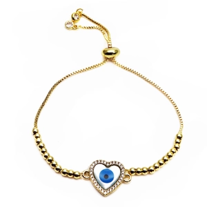 Macro detail of gold evil eye heart bracelet with zircon pavé and adjustable bolo chain