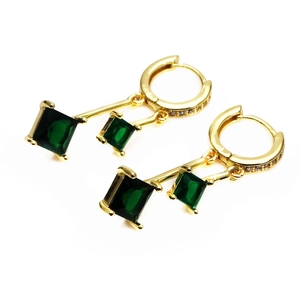 Detail van vergulde oorbellen met groene vierkante zirkoon en micro-pave ringontwerp