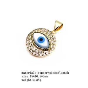 Evil eye charm detail with copper gold plating, cubic zirconia inlay, and shell center