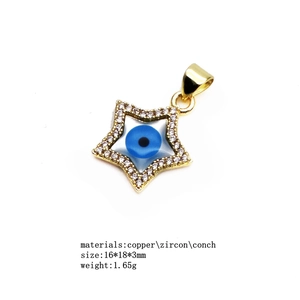Macro view of gold star evil eye charm with inlaid zircons and shell center detail