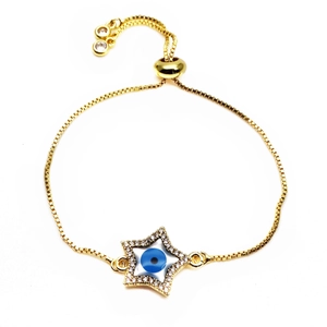 Macro detail of gold star bracelet featuring evil eye inlay and adjustable slider clasp