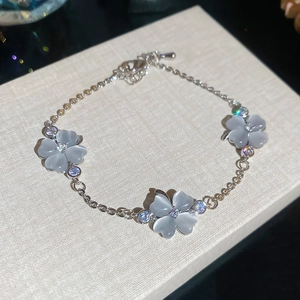 Detailansicht der Katzenaugenstein-Blumenanhänger an einem eleganten Silberarmband