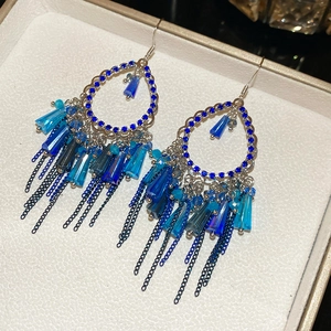Detailed macro shot of blue crystal chandelier earrings with elegant silver fringe chains