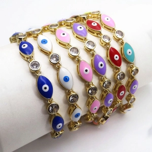 Detail van kleurrijke boze oog armbanden met goudlaag en zirkonia op wit fluweel