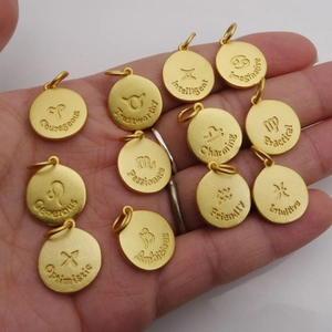 Set de doce colgantes dorados del zodiaco con símbolos y rasgos grabados