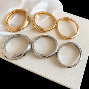 Minimalist geometric irregular metal bangles with smooth gold and silver mirror finish
