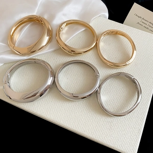 High-quality detail showing smooth metallic finish on gold and silver chunky bangles.