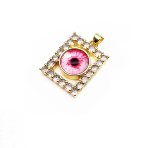 Macro detail of gold rectangle pendant with cubic zirconia and pink evil eye charm