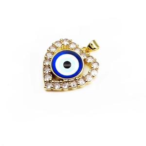 Macro view of gold heart-shaped evil eye pendant with cubic zirconia micro-pave