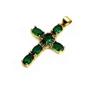 Gros plan du pendentif croix en cuivre doré avec pierres ovales en zircon vert