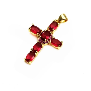 Détail du pendentif croix dorée avec pierres rouges ovales et oxydes de zirconium mauves