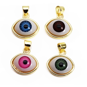 Makroansicht von vier ovalen Evil Eye Anhängern mit Goldrand in Blau, Braun und Pink