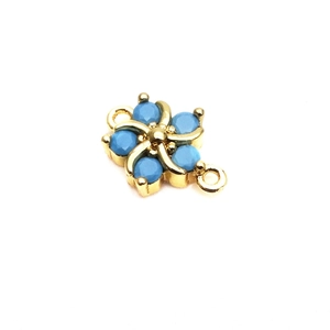 Detail of flower shaped golden jewelry connector with blue stones and double rings