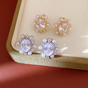 Eleganti orecchini ovali in zircone con alone di perle, in tonalità oro e argento.
