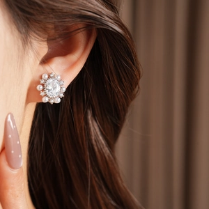 Vista dettagliata di eleganti orecchini a clip con zircone ovale e perla placcati oro 14k