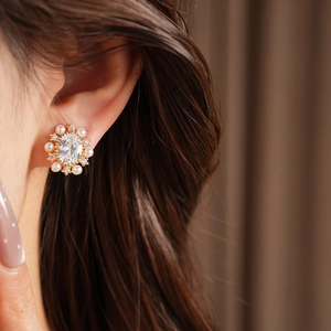 Dettaglio di orecchino a clip ovale con perle e zirconi placcato in oro 14k