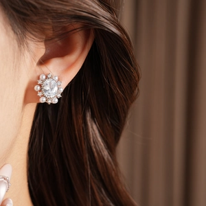 Primo piano di un elegante clip per orecchio in zirconia ovale con accenti di perle