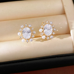 Primo piano di eleganti orecchini in zircone ovale con perle e placcatura in oro 14k