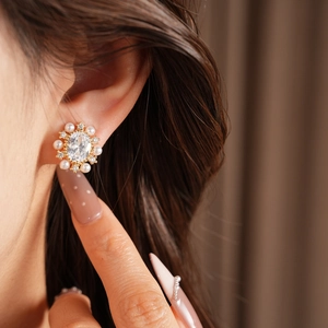 Dettaglio ravvicinato di orecchino a clip con perla ovale e placcatura in oro 14k