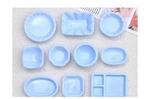 Detailed macro view of light blue resin miniature plates and bowls for DIY dollhouse decor