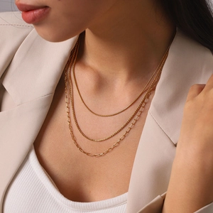 Close-up view of a triple-layered 18k gold plated stainless steel necklace worn by a model