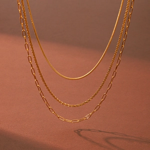 Detail of triple-layered 18k gold plated stainless steel necklace with various chain styles