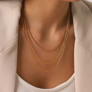 Detailed view of a triple-layered 18k gold plated stainless steel necklace on model